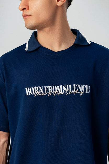 Close-up of LUNEX navy polo collar and "Born from silence" print
